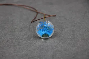 Dried blue flower resin pendant close up detail shot natural style necklace element accessory