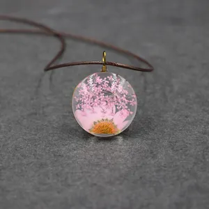 Handmade pressed flower resin round pendant necklace with pink dried botanical floral forest style.