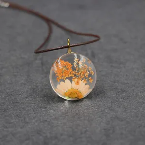 Close up detail of dried flower resin pendant, handmade nature style necklace jewelry.