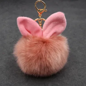 Cute plush bunny ear pom pom keychain, fluffy faux fur handbag charm accessory detail.
