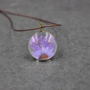Handmade dried flower glass pendant necklace, preserved purple daisy resin jewelry detail view.