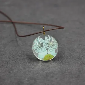 Close-up detail of the clear resin pressed flower pendant with dried florals inside.