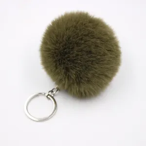 Dark green faux fur pom pom keychain detail, fluffy ball pendant for handbag or car keys.