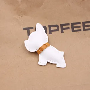 Nahaufnahme eines weißen Leder Französische Bulldogge Tasche Anhänger mit braunem Halsband.