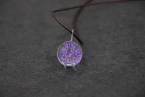 Handmade dried flower glass ball pendant necklace detail view showcasing purple botanical charm.