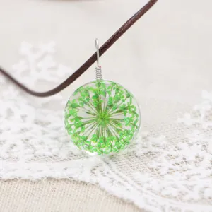 Handmade dried flower necklace featuring a glass ball pendant with green botanical lace floral charm.