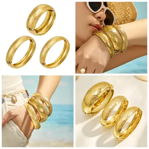 Close-up detail of textured gold-plated hinged bangles showcasing exquisite frosted patterns.