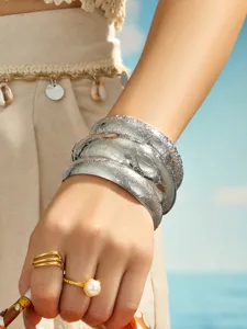 Detailed shot of wide open cuff bracelets with delicate embossed vintage patterns for women.