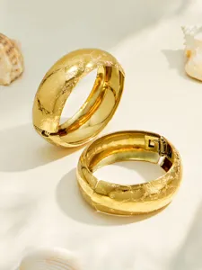 Detail view of wide gold plated stainless steel frosted cuff bangles with elegant textured surface.
