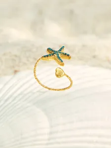 Detailaufnahme des vergoldeten Edelstahl Seestern Rings mit blauen Zirkonen und Herz.