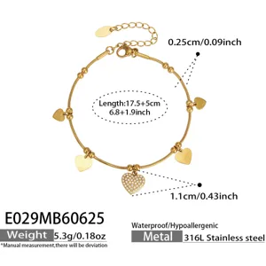 Detalle de pulsera de corazón de acero inoxidable bañado en oro de 18k con circonitas.