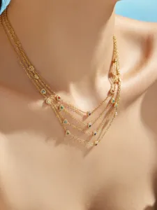 Exquisite multi-strand gold necklace detail featuring colorful zircon clover charms and shine.