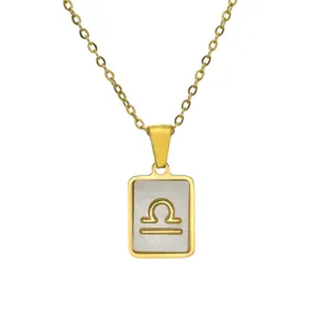 Close-up detail of 18K gold plated Libra zodiac sign pendant with mother of pearl inlay