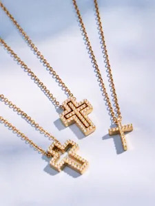 Close-up detail of three gold pavé cubic zirconia cross necklaces showcasing exquisite craftsmanship.