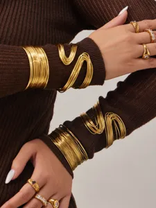 Vue détaillée de bracelets et bagues en fil métallique doré multicouche au design élégant.