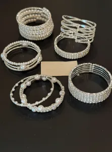 Vue détaillée de bracelets manchette en strass argentés et perles, design vintage de luxe.