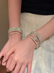 Gros plan détaillé du set de bracelets multicouches en strass et perles pour poignet élégant.