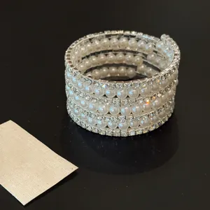 Gros plan détail du bracelet spirale multicouche en perles et strass, design très étincelant.