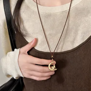 Details of the chic moon and cat pendant necklace with brown leather cord and tiger eye stone.