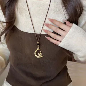 Cat moon pendant necklace with brown leather cord and tiger eye stone, elegant jewelry detail.