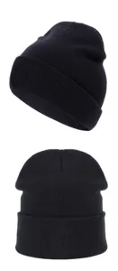 Detalle de gorro de punto acrílico negro, vista de cerca de la textura del gorro invernal.