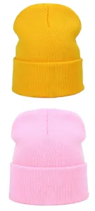 Vista detallada de gorros de punto de color liso en amarillo y rosa, gorros de invierno.