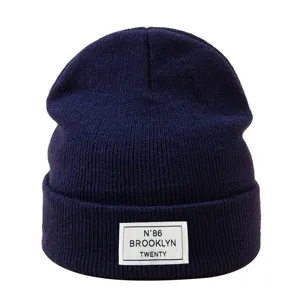 Bonnet tricoté d'hiver bleu foncé, bonnet chaud et stylé avec étiquette tissée pour usage quotidien.