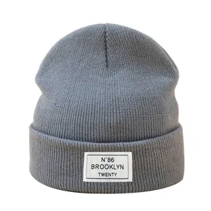 Bonnet en tricot gris hiver chaud bonnet en laine gros plan vue detaillee avec ecusson.