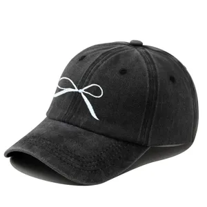 Élégante casquette de baseball noire délavée avec une belle broderie de nœud blanc.