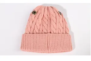 Pink kids knit beanie hat with cable knit texture and side metal buttons for winter warmth.