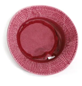 Detailed interior view of the red washed denim bucket hat, showing the lining and care label.