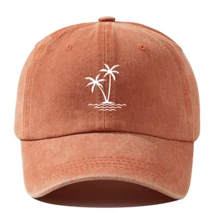 Detail view of washed cotton baseball cap featuring embroidered white coconut trees for summer.