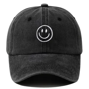Détail de la casquette noire lavée vintage avec une jolie broderie de visage souriant blanc.