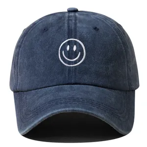 Vue détaillée de la casquette de baseball bleu marine lavée avec broderie smiley blanche.