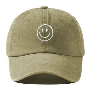 Vue détaillée de la casquette de baseball kaki souple avec visage souriant brodé blanc.