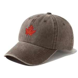 Close-up detail of the washed vintage brown baseball cap with red maple leaf design.