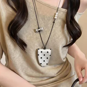 Detailansicht einer schicken Sonnenbrillen-Halterkette mit Polka-Dot Lederetui und Perlen.