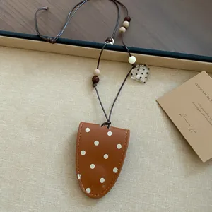 Braune Leder Polka Dot Brillenhalter Halskette mit Perlen und transparentem Herzanhänger.