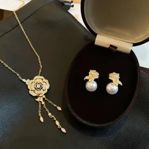 Ensemble de collier à pampilles en zircon doré et boucles d'oreilles en perles chic.