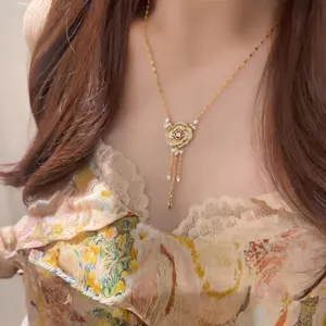 Vue détaillée d'un collier pendentif fleur de rose plaqué or avec des glands en zircon.