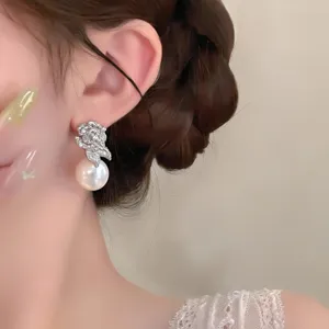 Gros plan détaillé d'une boucle d'oreille fleur en perle et zircon, design élégant.