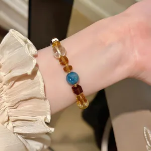 Primer plano detallado de una pulsera de cuentas de cristal y piedras preciosas en la muñeca