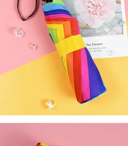 Farbenfrohes Faltschirm-Detail mit leuchtenden Regenbogen-Segmenten und kompaktem Design.