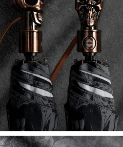 Automatischer Totenkopf Regenschirm mit bronzenem Metallgriff und schwarzem Schirmstoff.