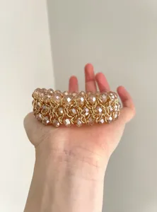 Detalle de pulsera de cuentas de cristal vintage multicapa, joya de cadena dorada.