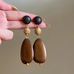 Boho Holz geflochtene Ohrringe Detail, Naturholz und Strohperlen Design für schicken Urlaubsstil.