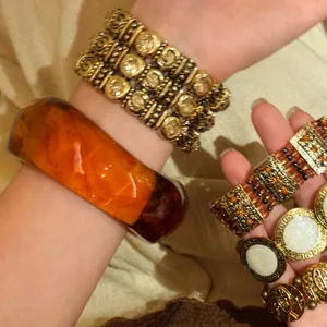 Detailaufnahme eines Vintage-Harzarmbands und elastischen Metallarmbands im Retro-Look.