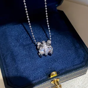 Gedetailleerde close-up van een zirkoon geplooide strikhanger ketting in een doos.
