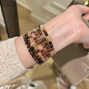 Close-up of multi-layer tiger eye stone and crystal beaded bracelet worn on wrist elegantly.