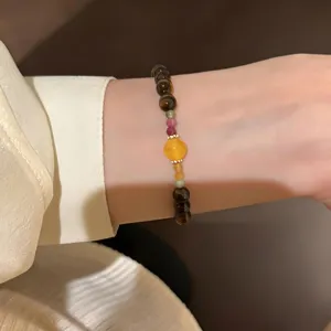 Close-up detail of the neo-Chinese retro tiger's eye crystal beaded bracelet on wrist.